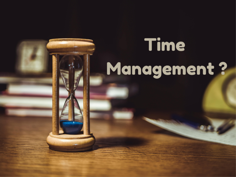 Sand clock on desk symbolizing time management and productivity.